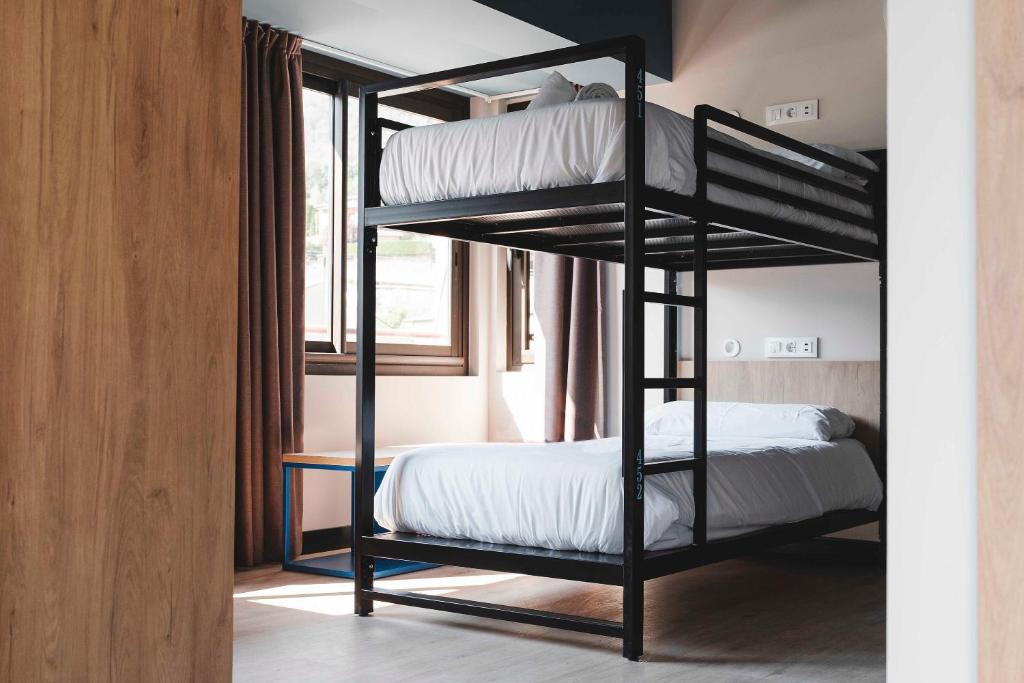 马萨纳Font Andorra Hostel的一间卧室设有两张双层床和一扇窗户。