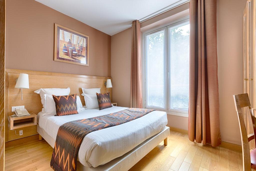 巴黎格兰德酒店的一间卧室设有一张床和一个大窗户