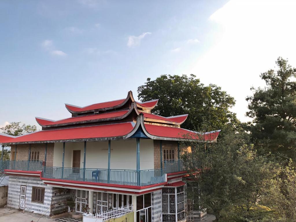 穆里Shangrilla House Murree, Bhurban的一座有红色屋顶和树木的古老建筑