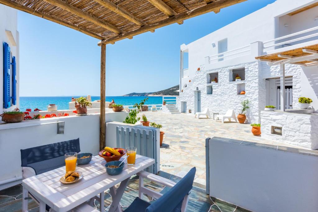 普拉提伊亚洛斯西弗诺斯Ammos Sifnos Village的一个带桌椅的庭院和大海