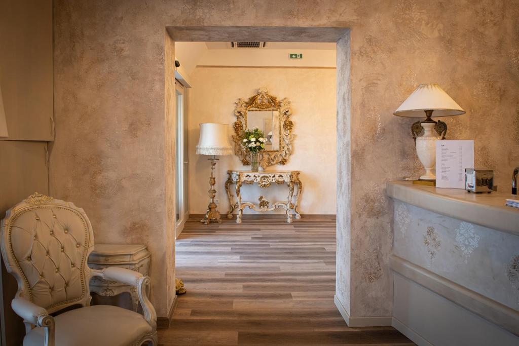 安科纳德拉罗萨酒店的走廊上设有椅子、桌子和镜子