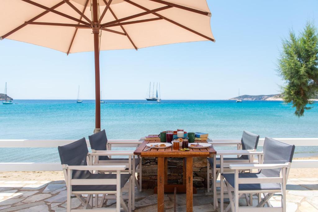 普拉提伊亚洛斯西弗诺斯Grandma's sifnos house的海滩上的桌椅和遮阳伞