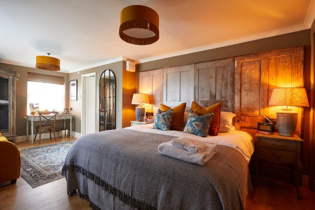 科舍姆The Quarrymans Arms的一间卧室配有一张大床和木制床头板