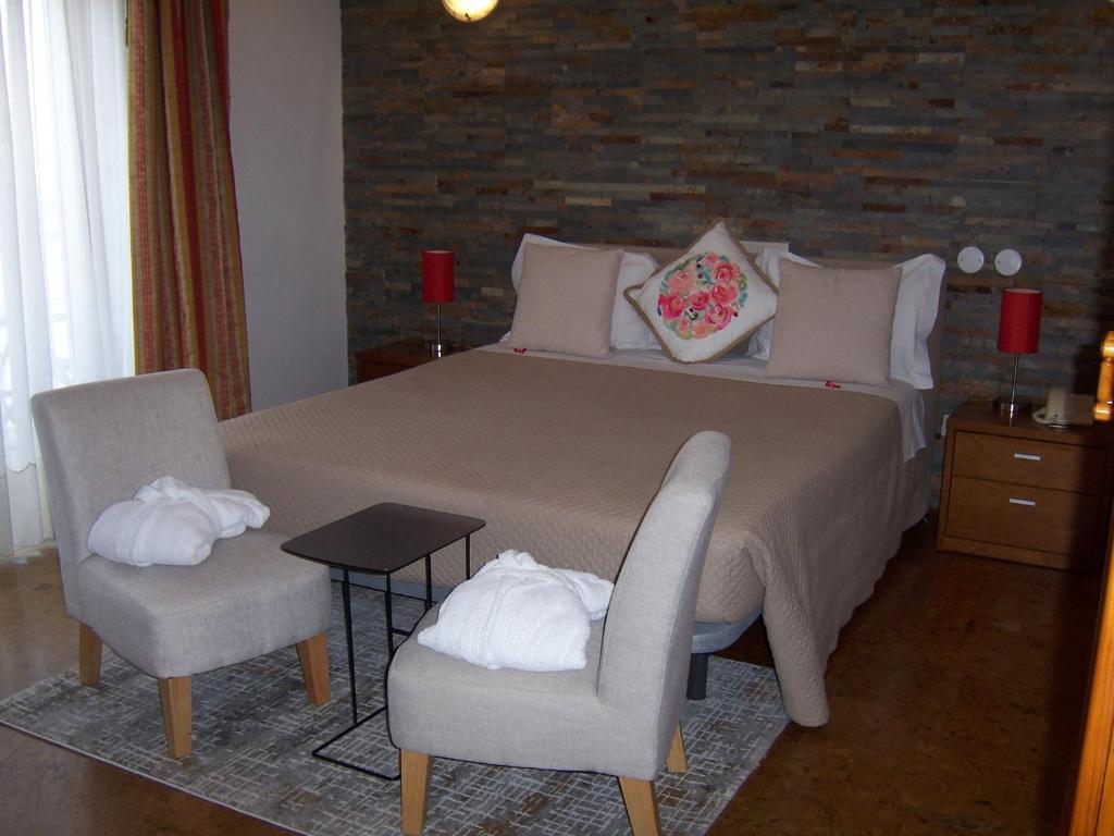 布拉干萨圣塔阿波洛尼娅酒店的一间卧室配有一张大床和两把椅子