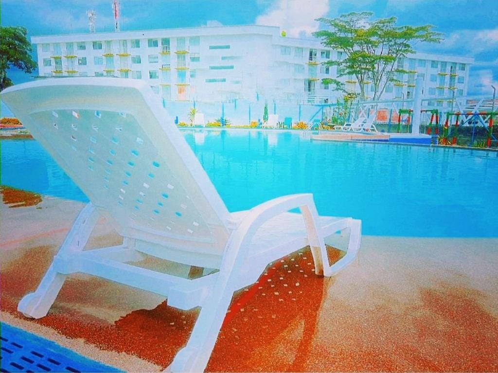 蒙特内哥罗Apartamento privado a 2 kilometros del Parque del Café的游泳池旁的白色摇椅