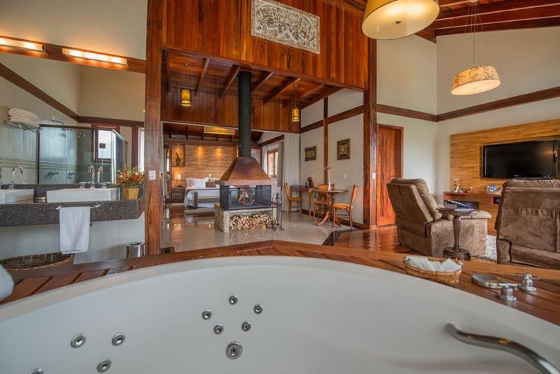 蒙特韦尔迪Mirante da Colyna Hotel & SPA的带浴缸的大浴室和客厅。