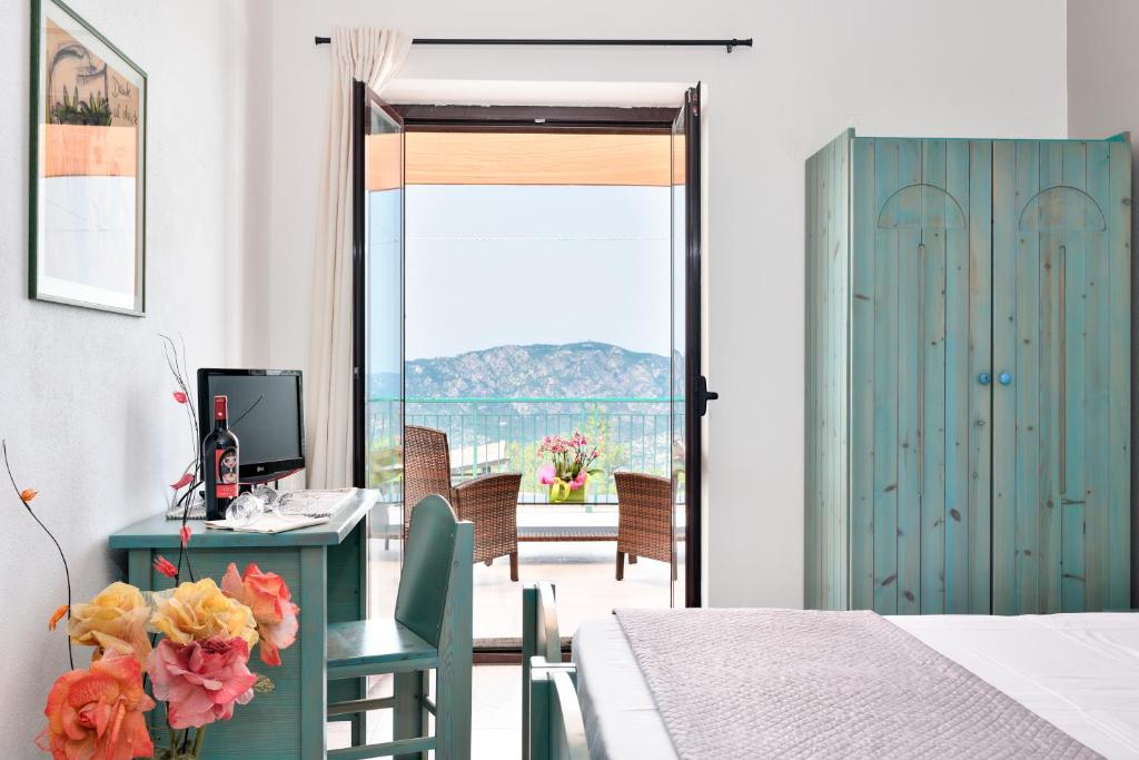 奥列纳S'Enis Monte Maccione的一间卧室配有一张桌子、一台电脑和一个窗口