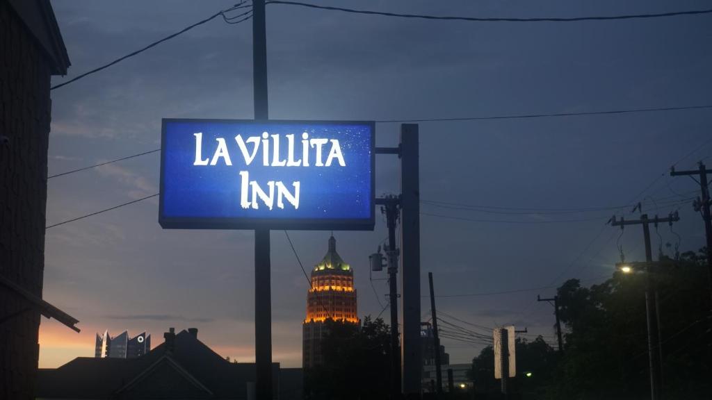 圣安东尼奥拉维利塔酒店的带有背景建筑的标志,读了la willilitia旅馆