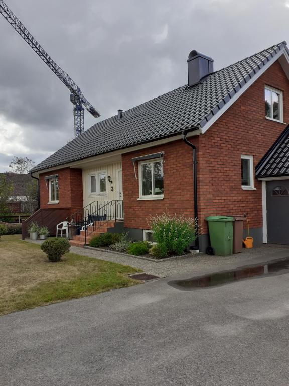 乌拉勒德Villa mitt i Ullared - 400m till Gekås的一座红砖房子,后面有起重机