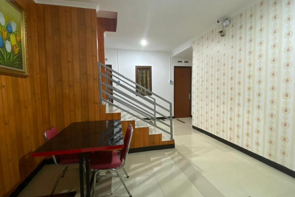 雅加达RedDoorz Plus @ Rawamangun的一间带桌子和楼梯的用餐室