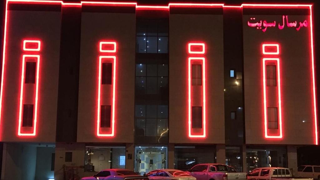 利雅德مقصورة مرسال سويت的前面有红色 ⁇ 虹灯标志的建筑