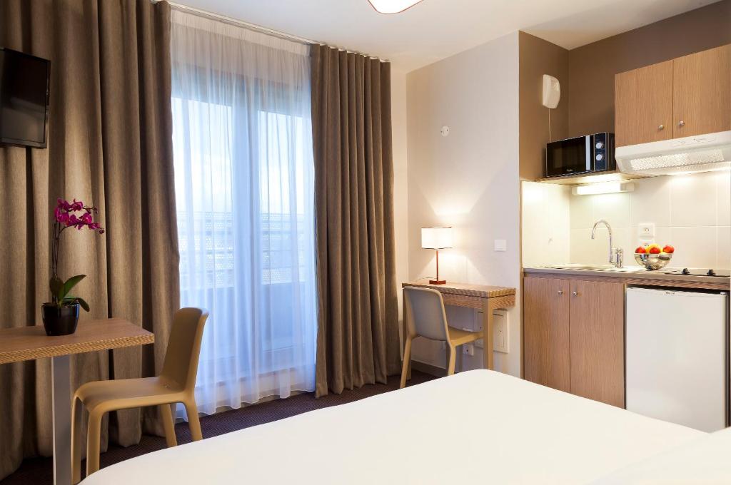 安纳马斯Nehô Suites Porte de Genève的酒店客房带一张床和一个厨房