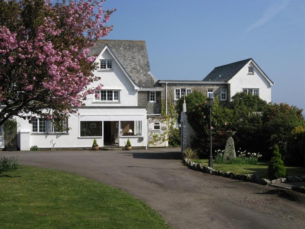 法尔茅斯特雷拉瓦酒店的前面有一棵开花的树的白色房子