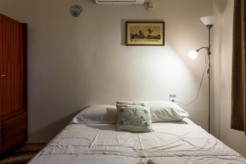 哥鲁拜克Apartment & Rooms Aleksandar的一间卧室配有一张带枕头的床