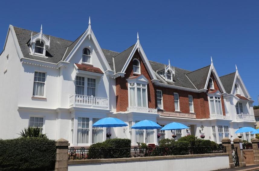圣赫利尔泽西拉尼米德苑酒店 的前面有蓝色伞的大白色房子