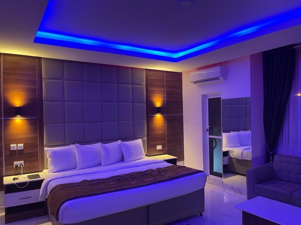 拉各斯Presken Hotel @Oniru的一间卧室配有一张蓝色灯光的大床