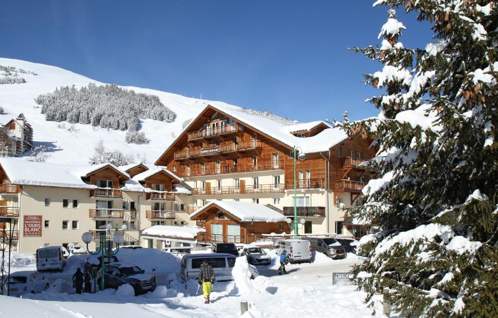 莱德萨阿尔卑斯奥达尔伊白熊公寓式酒店的雪地滑雪小屋,有车辆停放