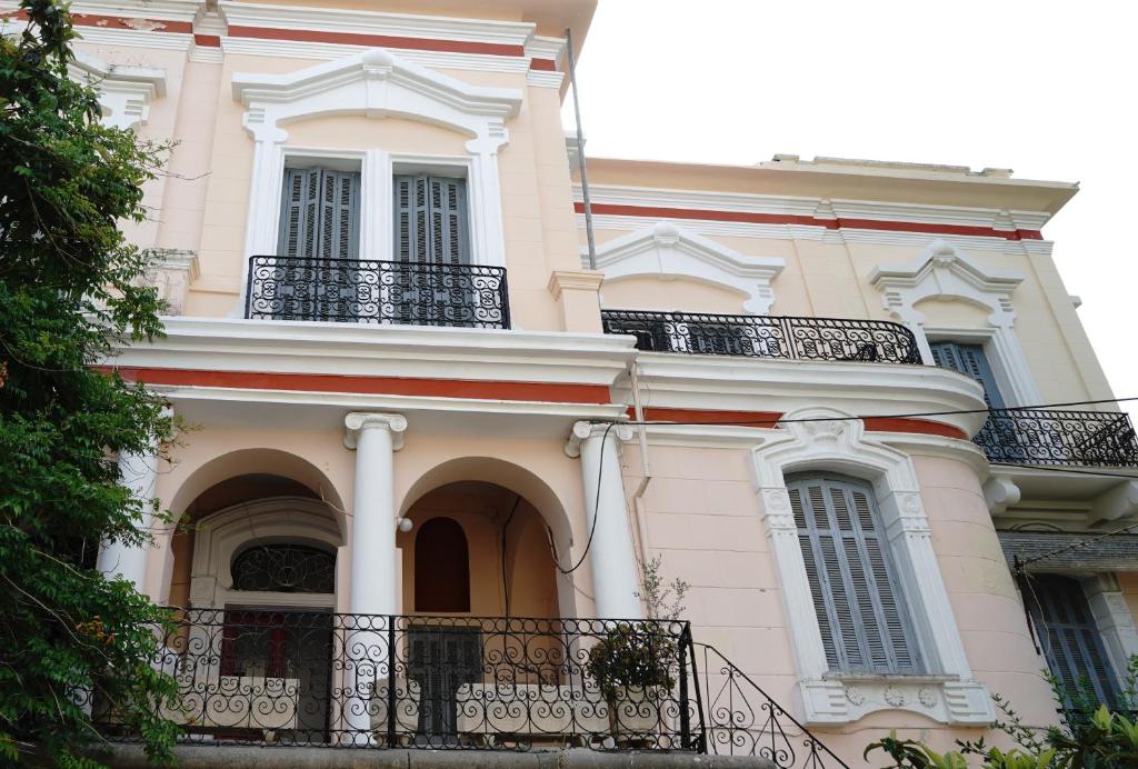 伊古迈尼察The Pitoulis Mansion的一座大型白色建筑,设有阳台和窗户。
