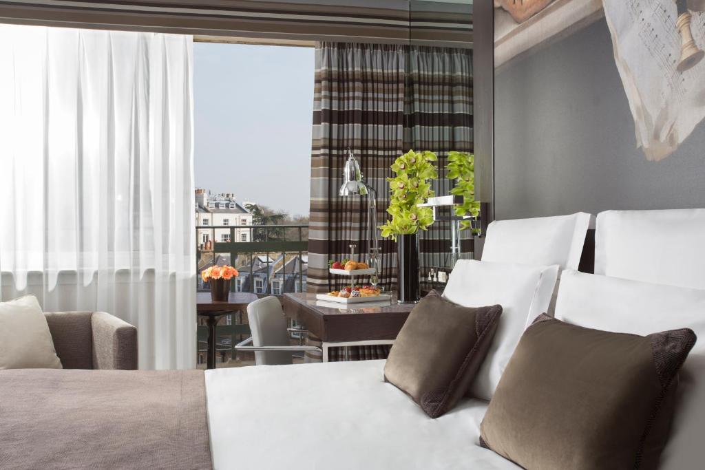 伦敦Jumeirah Lowndes London的一间卧室设有一张床和一间用餐室