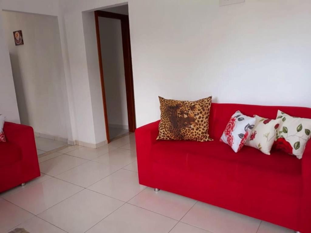 甘博阿Casa Azul Gamboa的一张红色的沙发,上面有一大堆枕头
