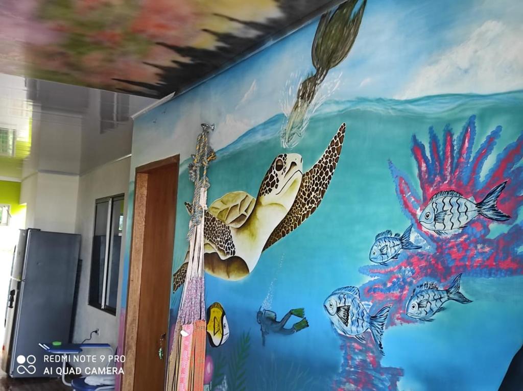 SantiagoHostal mis dos ángeles的墙上有海龟壁画的房间