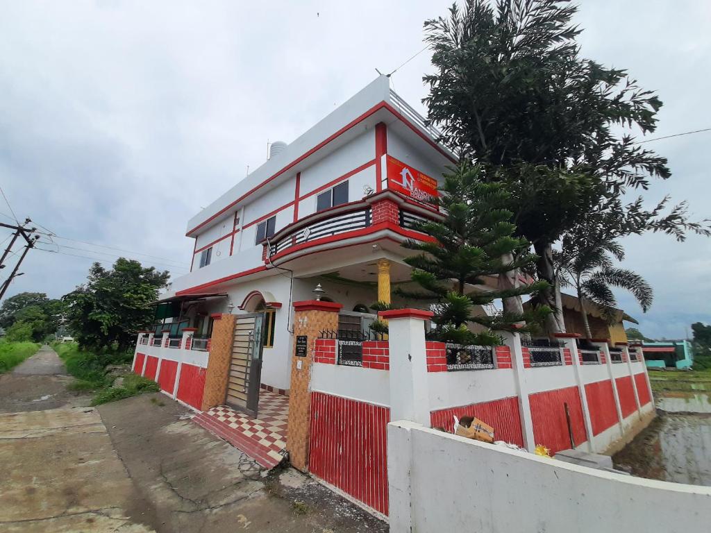 德拉敦Nandini Homestay的一座红色和白色的房子,设有围栏