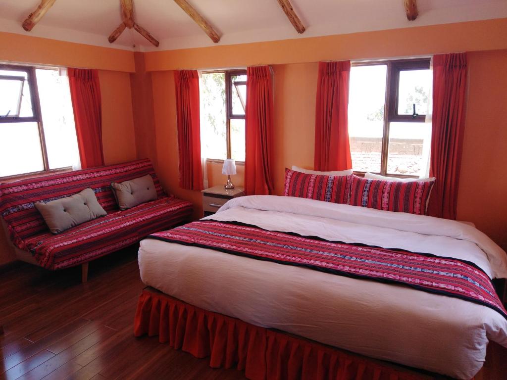 Llachon"Casa de Valentin"的一间卧室配有红色窗帘、一张床和一张沙发