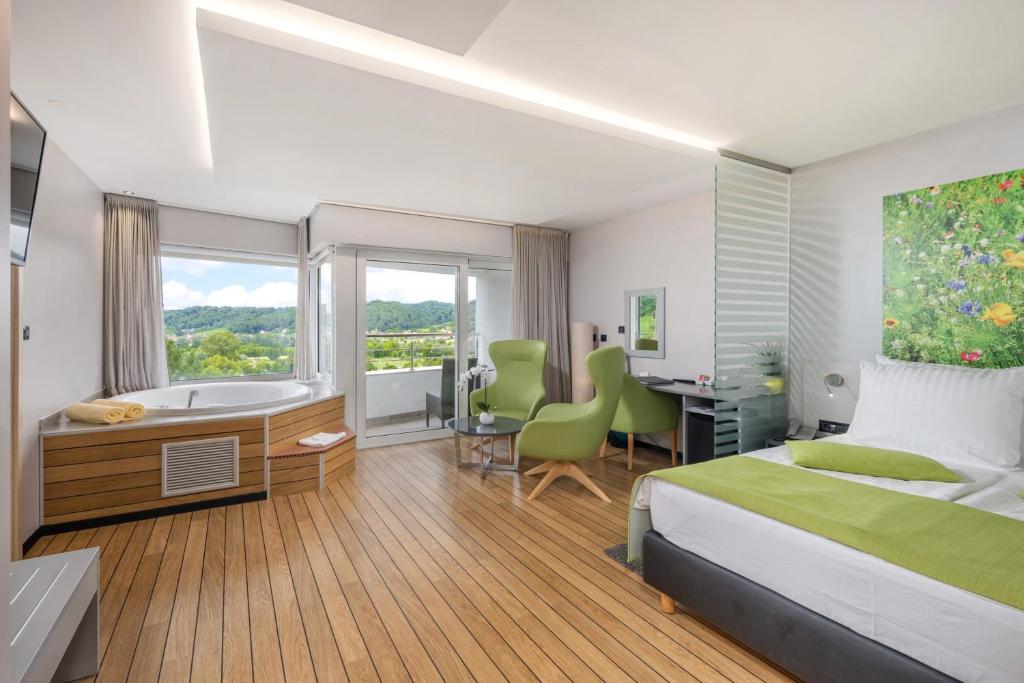 克拉平斯凯托普利采马格达莱纳别墅疗养酒店的一间卧室配有一张床、一张书桌和一个浴缸