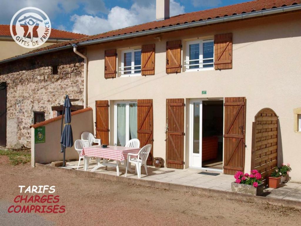 Saint-Alban-les-EauxGîte Saint-Alban-les-Eaux, 3 pièces, 4 personnes - FR-1-496-75的房屋配有桌椅和遮阳伞