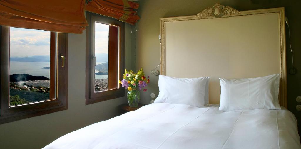 马克里尼撒阿拉马里斯酒店的卧室配有白色床和2扇窗户