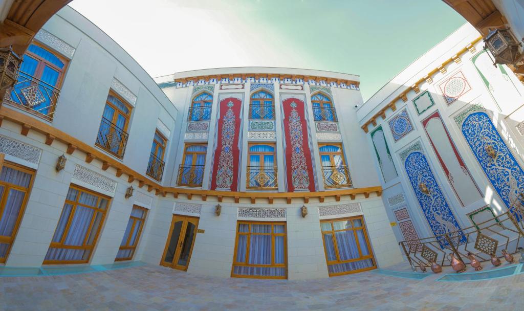 布哈拉Al Imran Boutique Hotel的一座带五颜六色的窗户和门的大型建筑