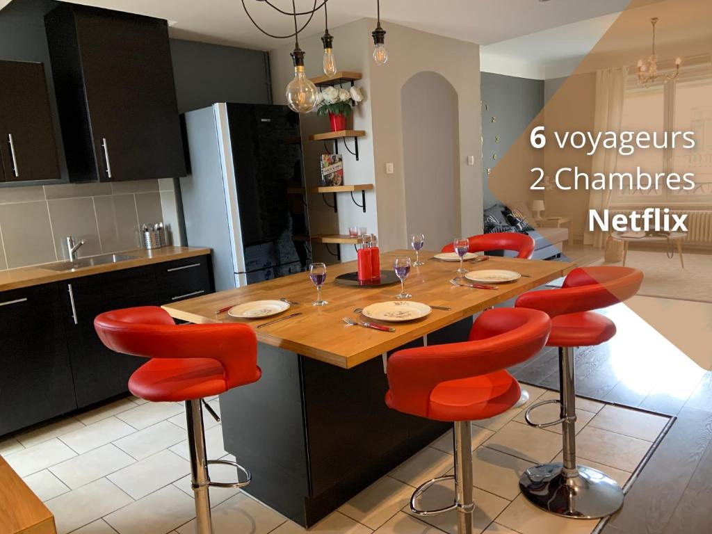 梅斯Le Saint-Bernard的厨房配有木桌和红色椅子