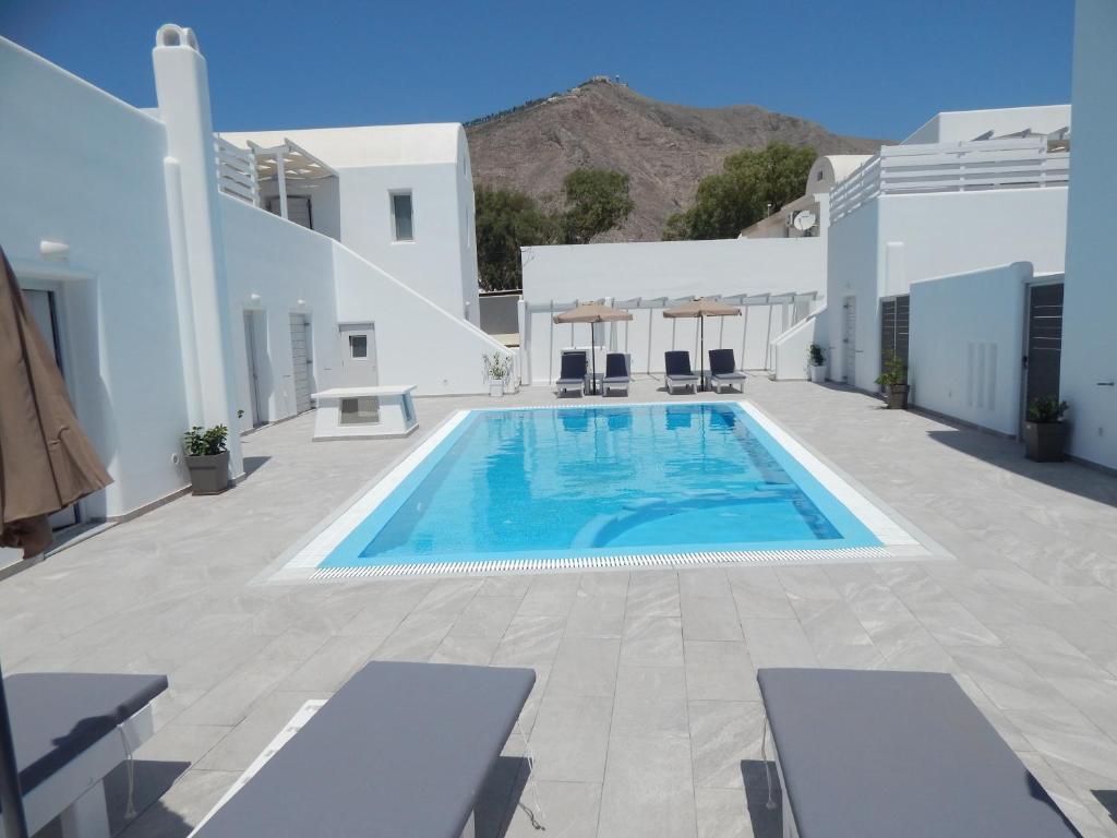 佩里萨Petra Aqua Villa的一座位于庭院的游泳池,庭院内有白色的建筑