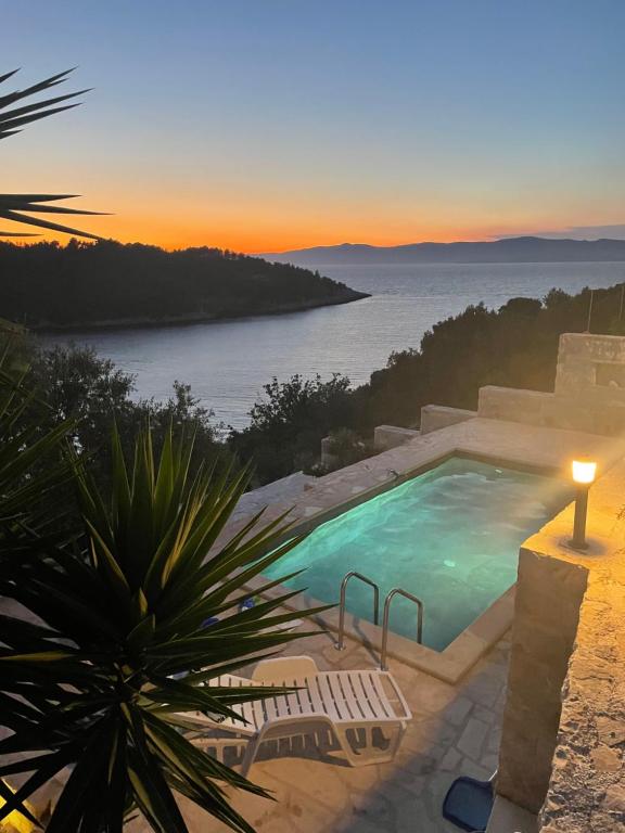 尼亚卢卡Holiday Home Tranquility的日落时分享有海洋美景的游泳池