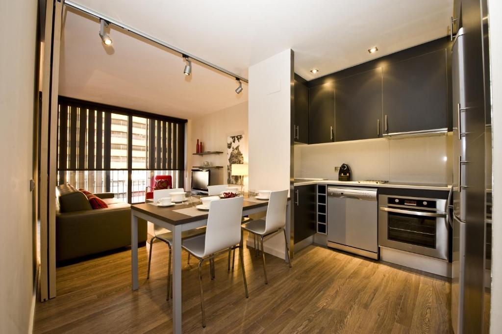 巴塞罗那卡斯普74公寓式酒店的一间厨房,里面配有桌椅