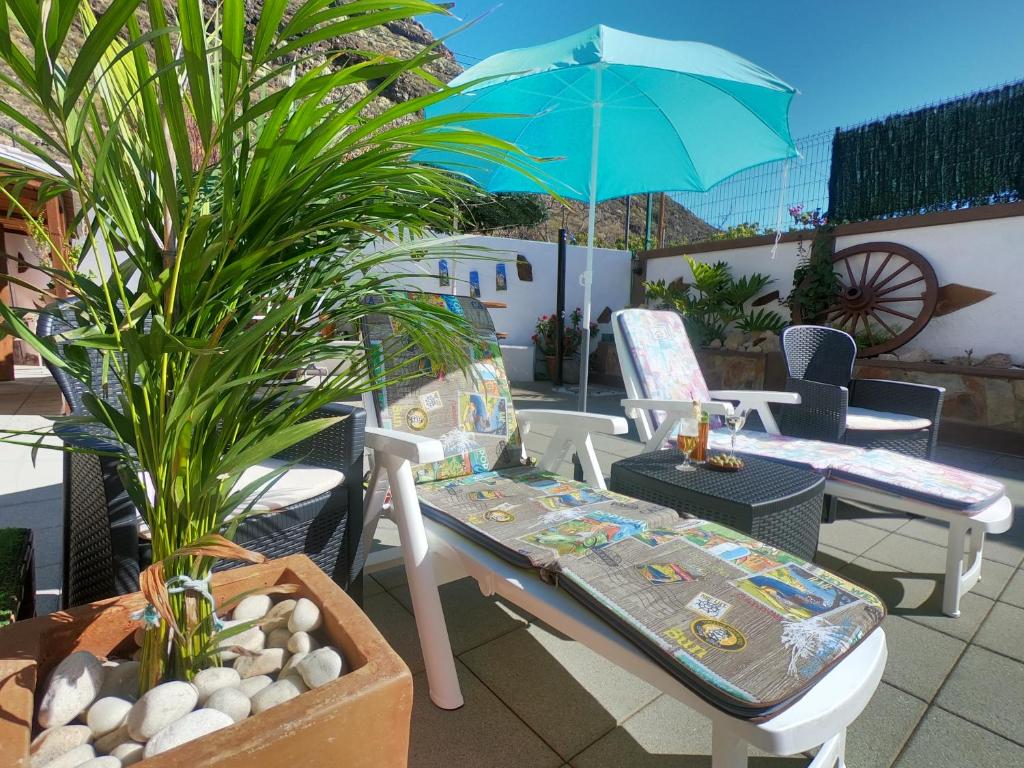 坎德拉里亚Abi&Lei VV的庭院配有桌椅和遮阳伞。