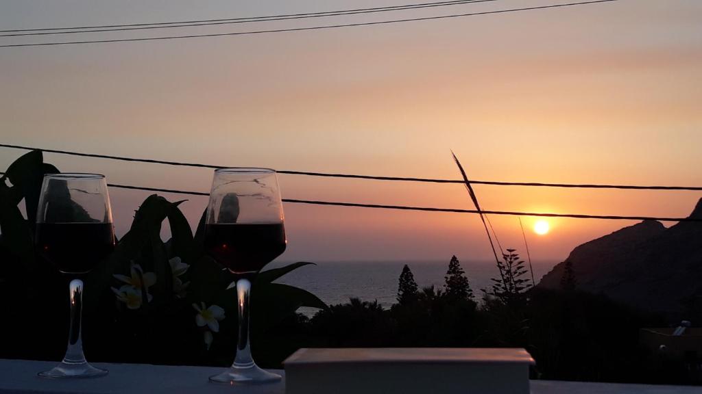 阿尔卡萨Sunset Suites 'Annada的两杯酒坐在桌子上,欣赏日落美景