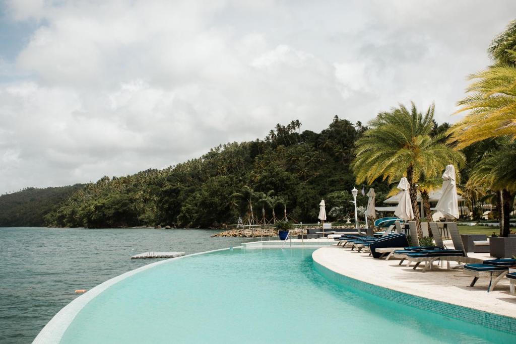 圣塔芭芭拉-山美纳Ocean View Villa/Luxury Puerto Bahia Resort/Samaná的水体旁边的游泳池