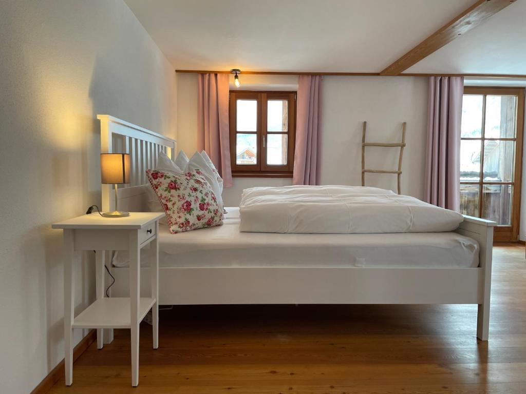 哈尔布莱希Bergien的卧室配有一张白色的床、桌子和台灯