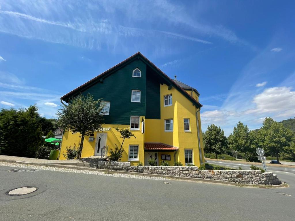 布兰肯堡Landgasthaus Zander的路旁的一座黄色和绿色的房子