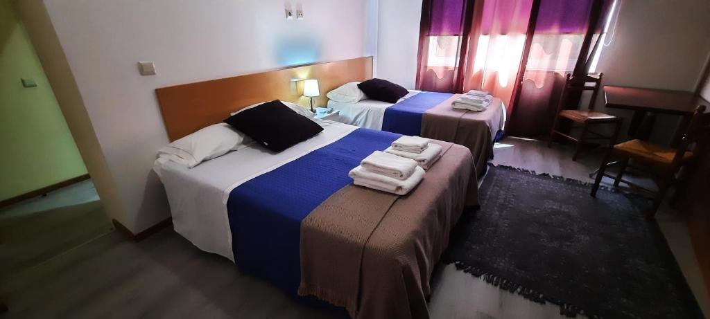 比索达雷加Vale do Rodo Residencial的两张位于酒店客房的床,配有毛巾