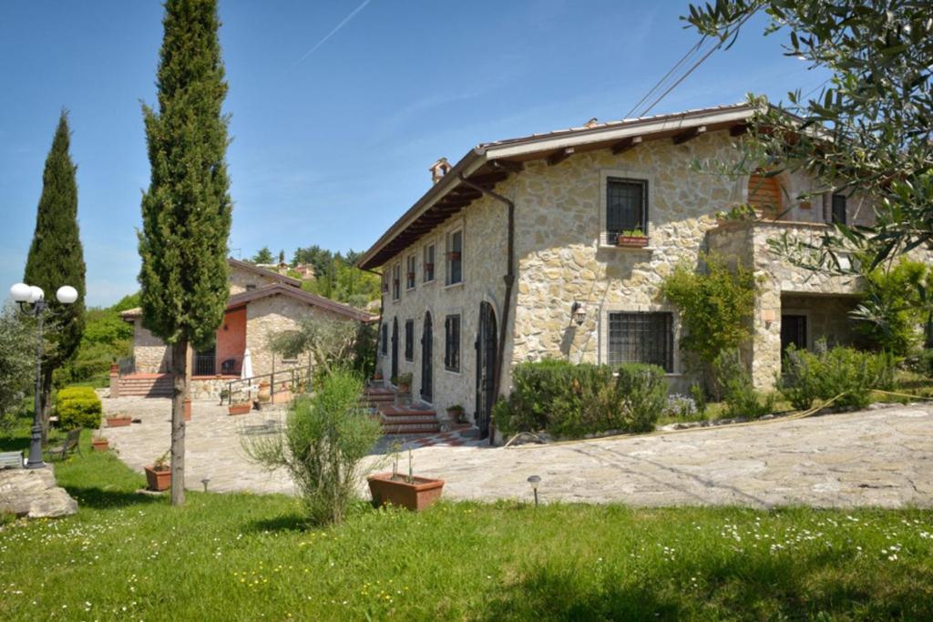 Castel San Pietro Romano亿卡萨乐德勒盖斯特公寓的一座古老的石头房子,前面设有一个花园