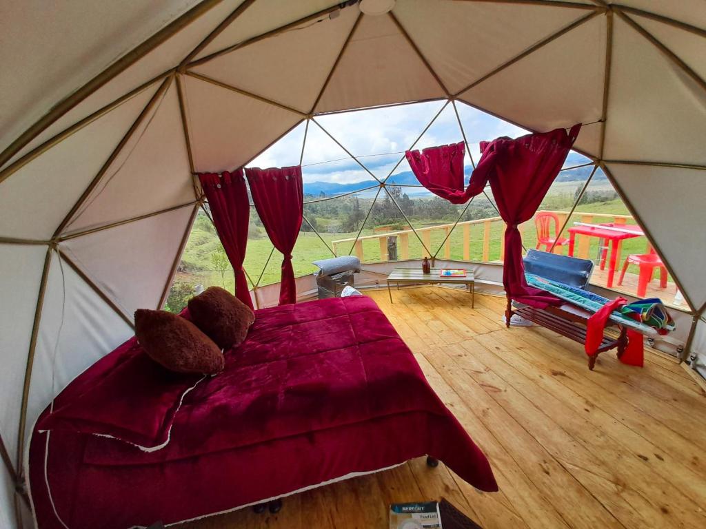 瓜斯卡Skyline Glamping Guasca的帐篷内的卧室,配有一张床和椅子