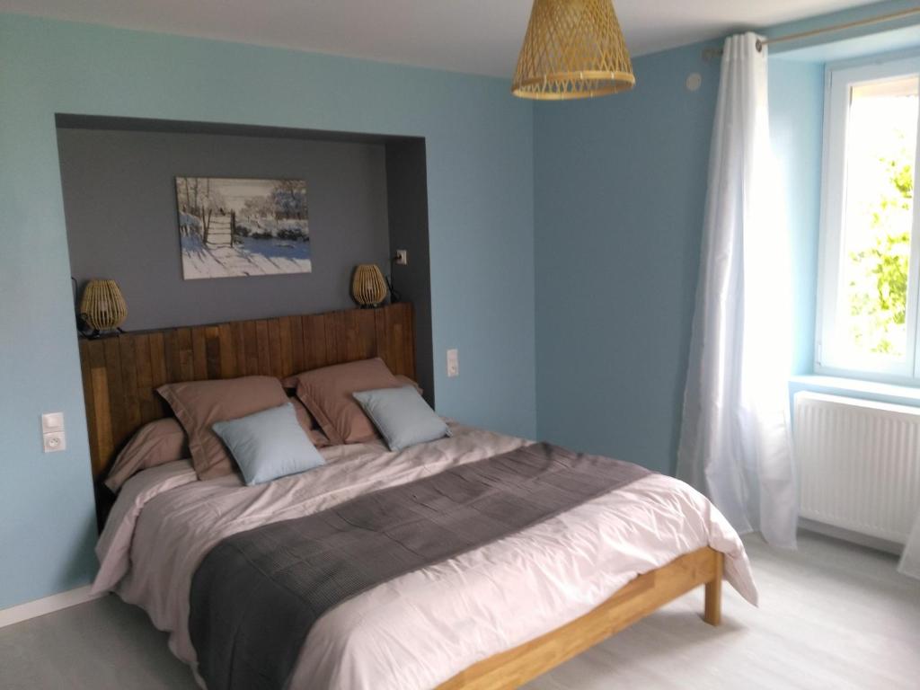 Lachapelle-sous-ChauxLes Chambres d Odile的一间卧室配有一张带蓝色墙壁的大床