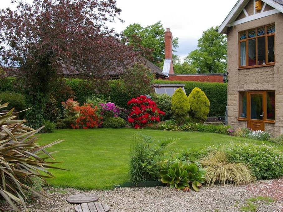 诺曼顿The Grange的绿草成荫的院子,花草成荫的房屋