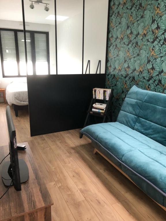 迪纳尔Studio centre Dinard的客厅配有蓝色的沙发和床。
