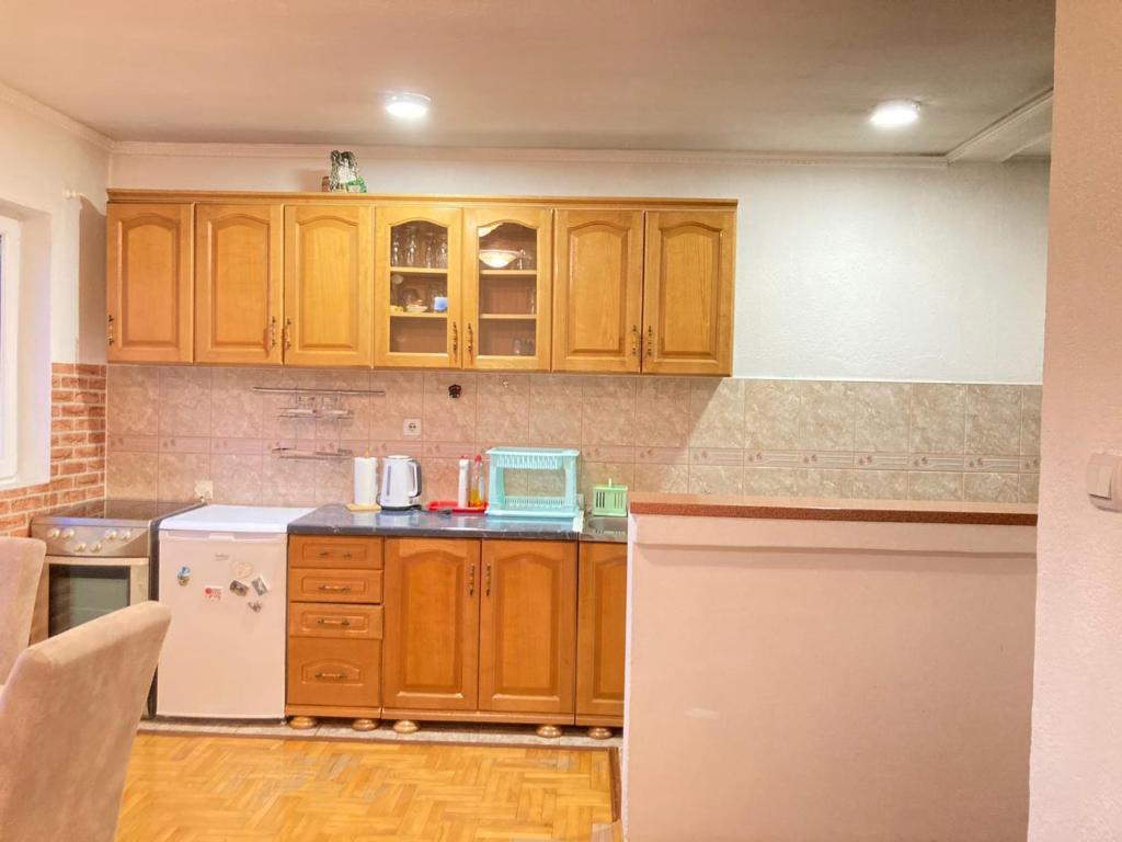 扎布利亚克Guest House Nena的厨房配有木制橱柜和白色冰箱。