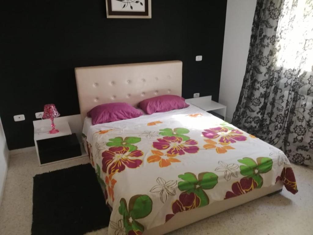 El Aouinarésidence les jardins的一间卧室配有带粉红色枕头的床