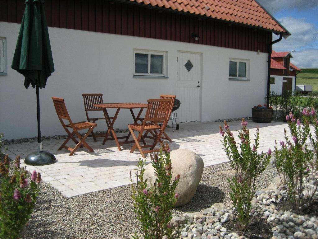 Skårby格茨布安达酒店的庭院配有桌椅和遮阳伞。