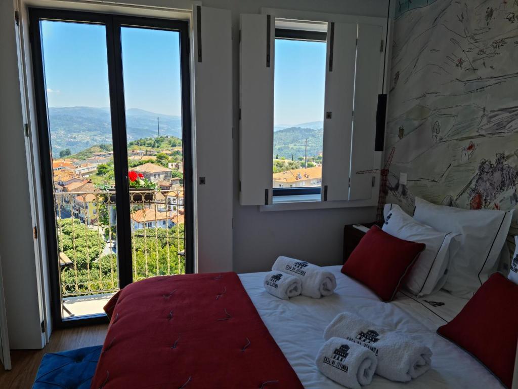 辛方伊什Casa da Zéfinha, em Cinfães, no Douro的一间卧室配有一张大床和毛巾